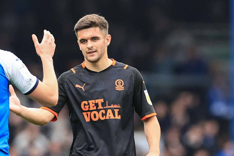 Blackpool player Jake Daniels high fives a teammate on the field