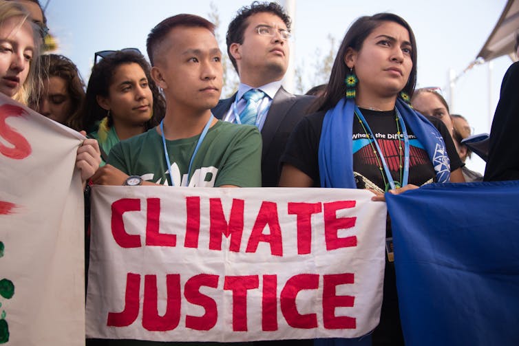 People holding a sign reading 'Climate Justice'