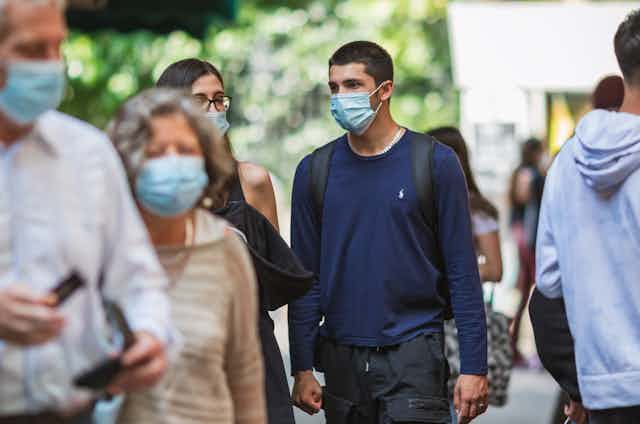 People walking wearing masks.