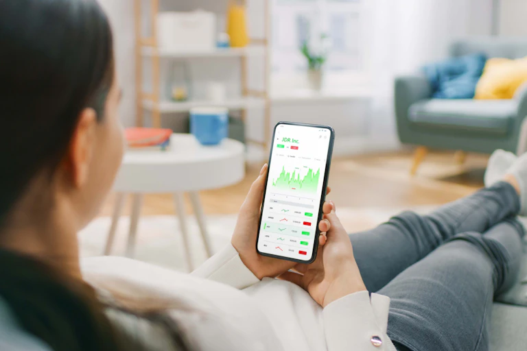 A person looks at a phone screen displaying investment information