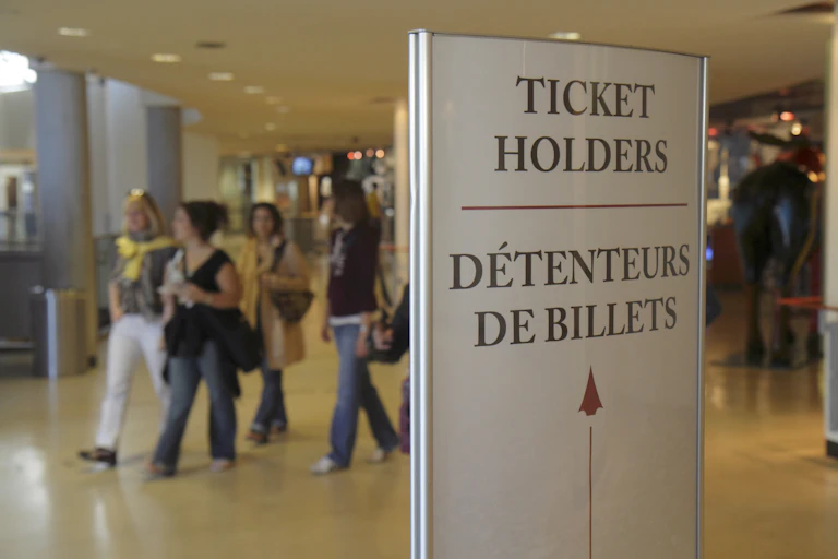 People walk past a sign in both French and English