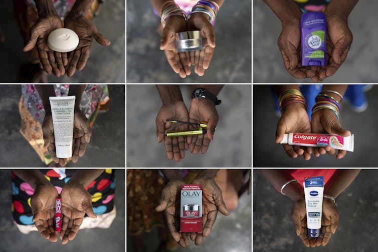 The hands of women hold various beauty and toiletry products like soap, lotion and toothpaste.