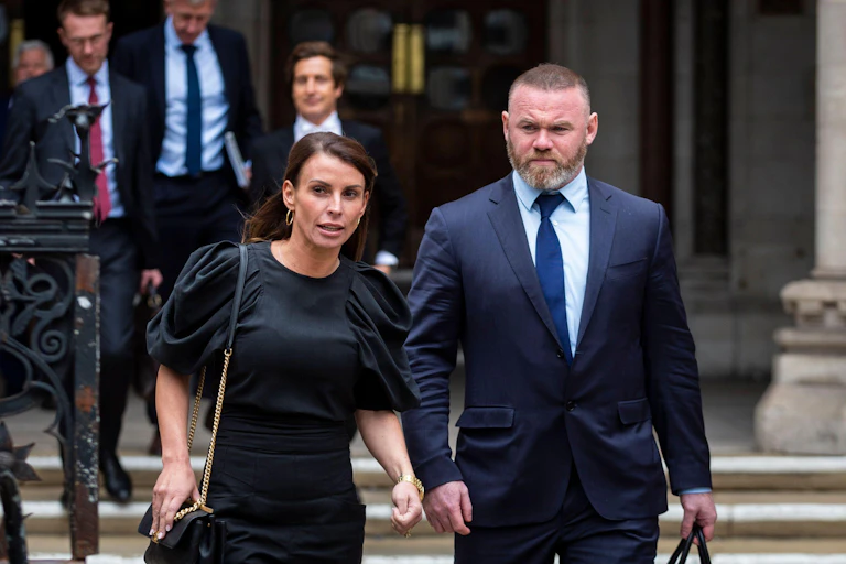 Coleen Rooney and Wayne Rooney walk away from the high court