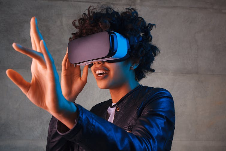 a woman wearing a vr headset with an outstretched hand