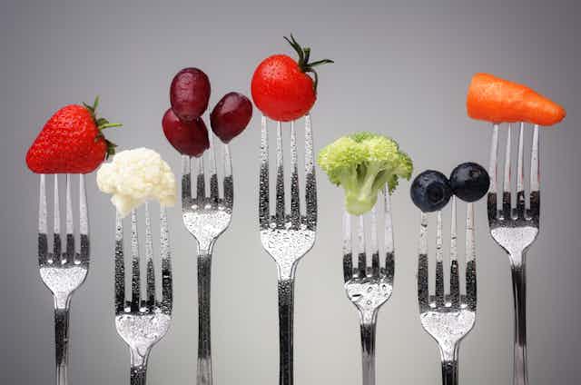 A row of forks with different healthy foods on each