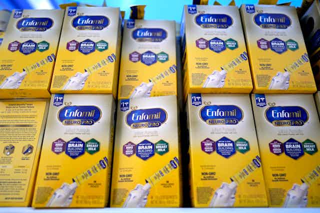 Two stacks of baby formula in yellow and white boxes
