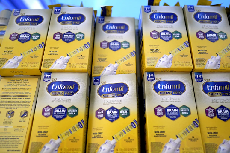 Two stacks of baby formula in yellow and white boxes