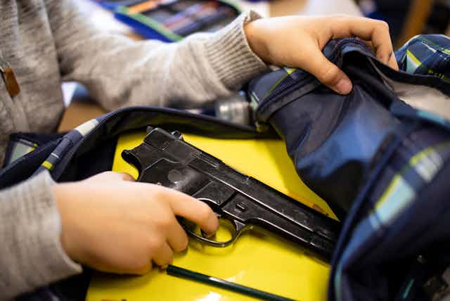 A student places a gun in their backpack.