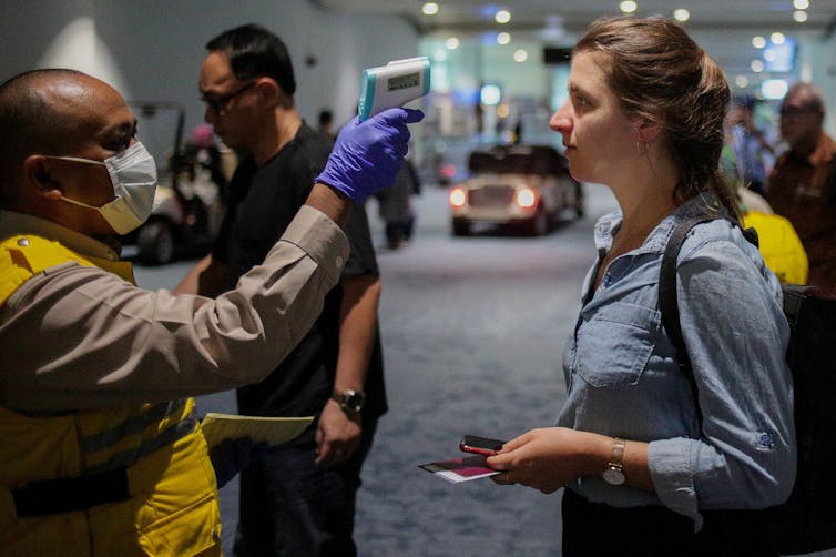 Personne se faisant tester la température à l'aéroport