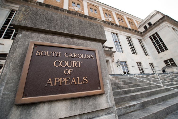 Exterior of a courthouse in Columbia, South Carolina. The sign in the foreground says: South Carolina Court of Appeals.