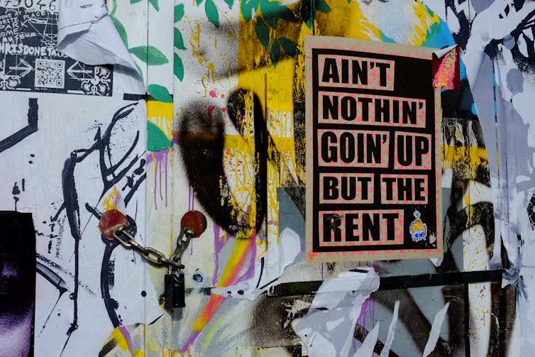 Graffiti with poster protesting rent rises.