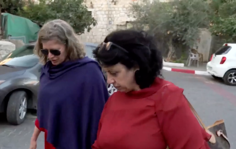Two women walking and talking in Jerusalem street.