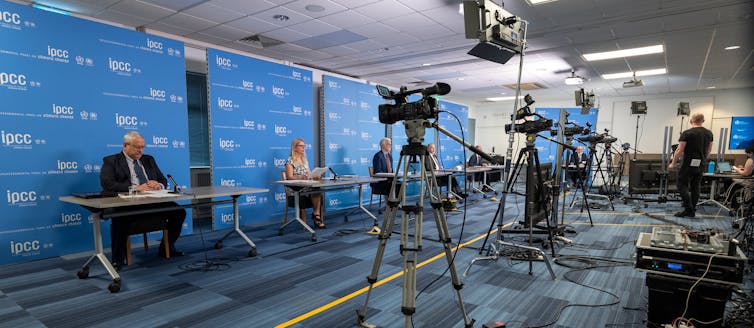 People in press conference facing cameras