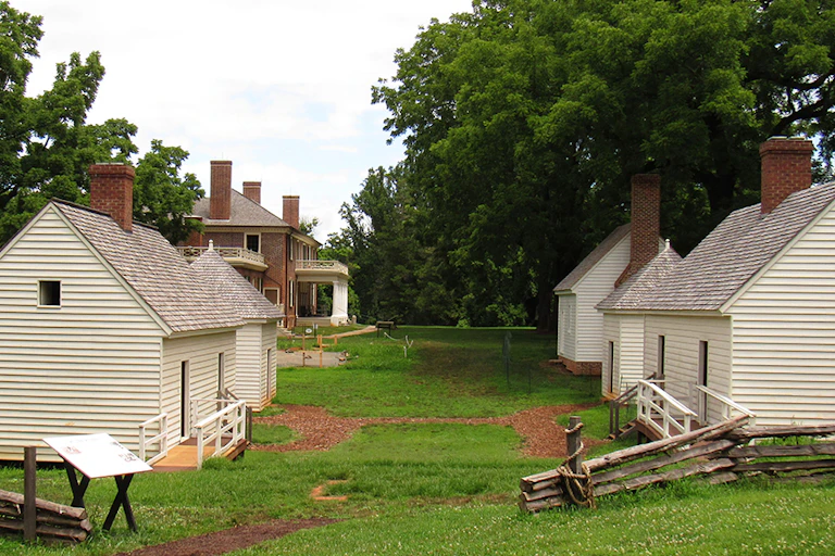 Small whitewashed slave cabins with Madison's home in the background
