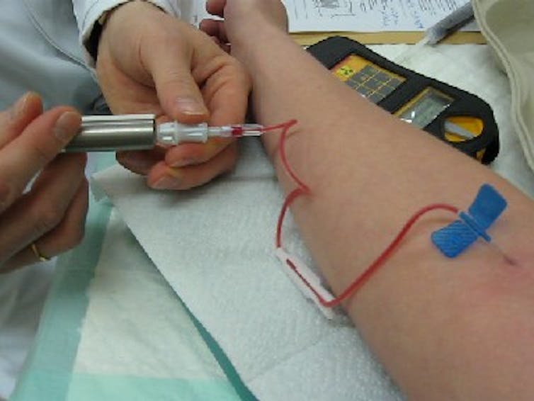 A person getting an injection of a fluid.