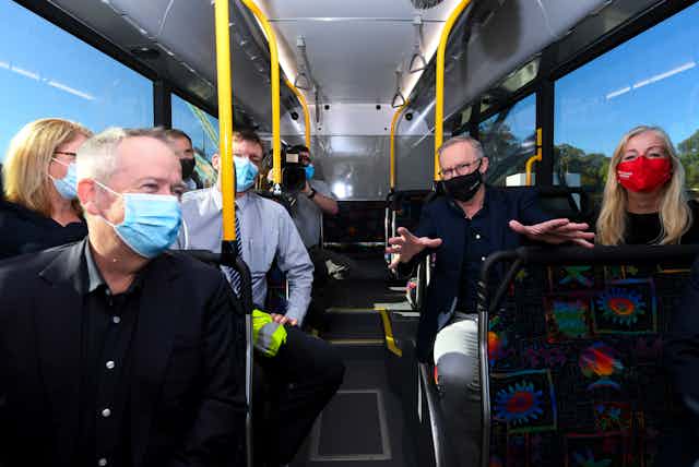 several adults on bus wearing masks