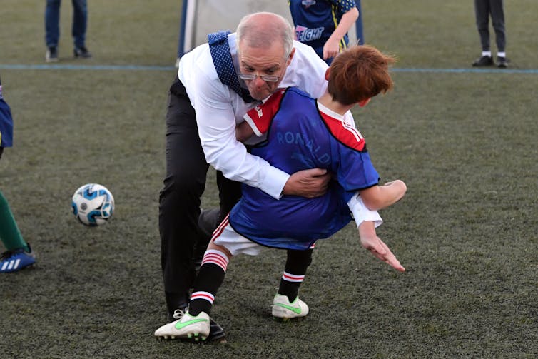 Scott Morrison crash tackles a child at the Devonport Strikers Soccer Ground.