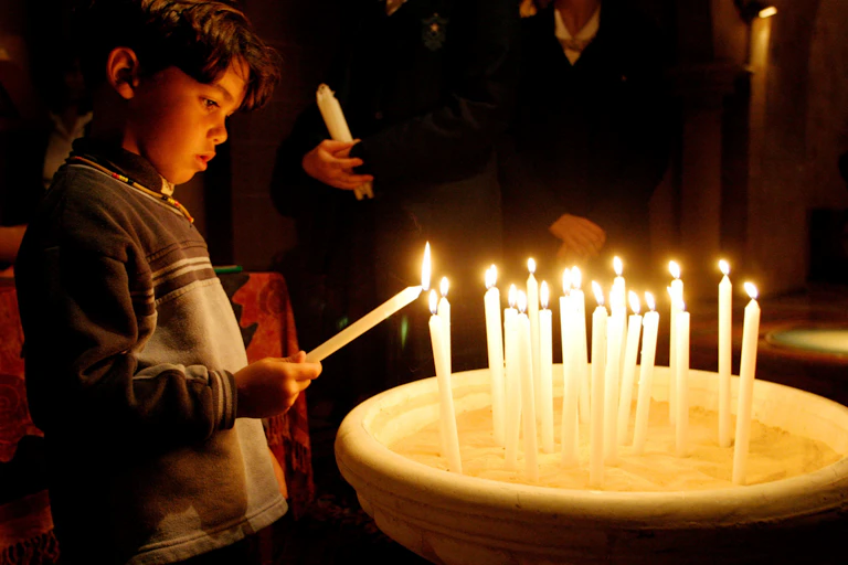 A young child lights a candle to commemorate the Stolen Generations.