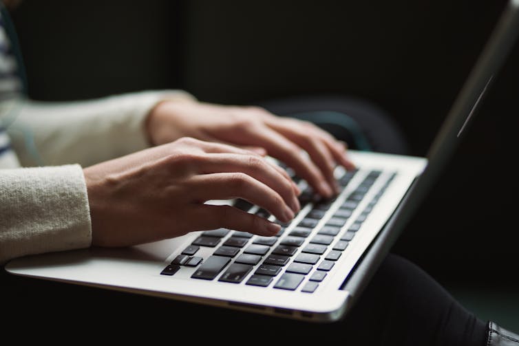 hands on laptop keyboard