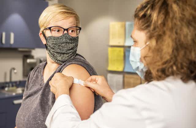 Nurse puts a bandaid on a patient's arm after a vaccination.