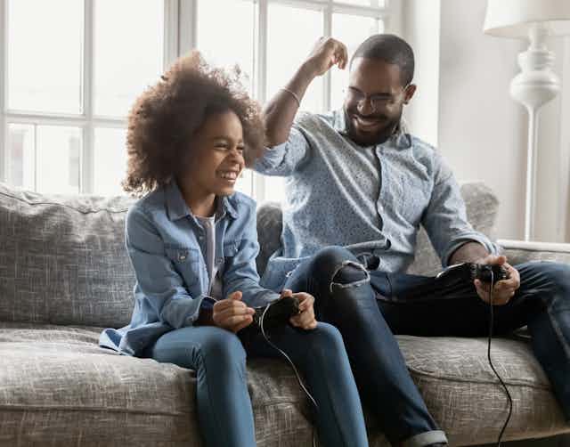 Father and daughter playing video game