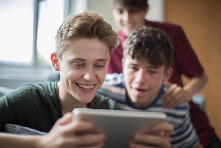 Teenage boys playing on tablet