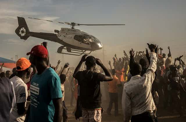 A chopper lands at the site of a political rally