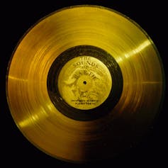 A golden colored record with 'The Sounds of Earth' written in the center.