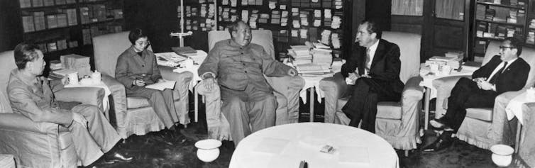 President Richard Nixon confers with Chinese Communist Party Chairman Mao Tse-tung as they sit in comfy chairs.