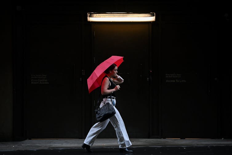 Woman with red umbrella running