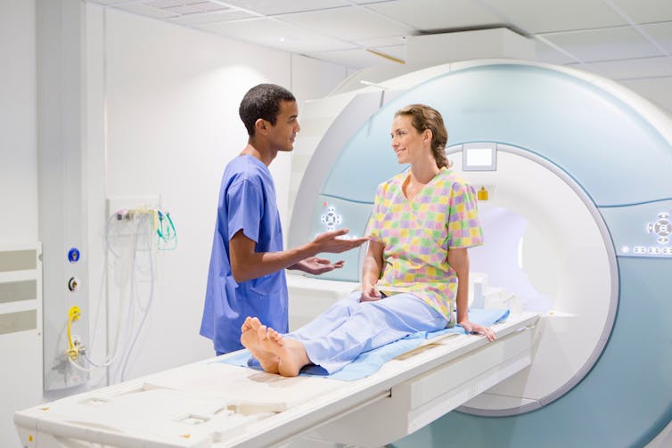 Woman undergoing an MRI talks to her nurse.