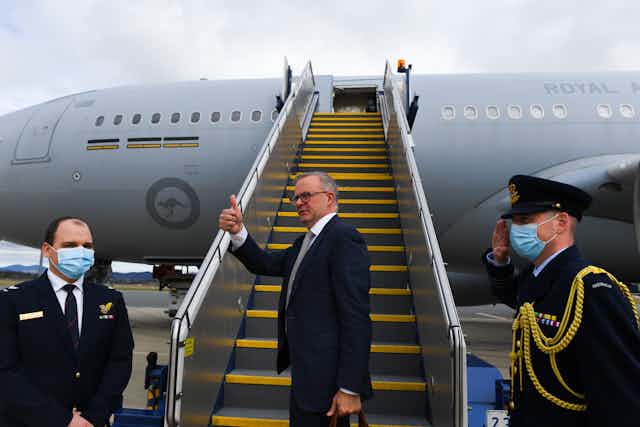 Anthony Albanese gives the thumbs up as he boards a plane.
