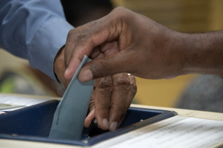 Un homme dépose son bulletin de vote lors du second tour des élections législatives françaises dans un bureau de vote à Pointe-a-Pitre, le 17 juin 2017.