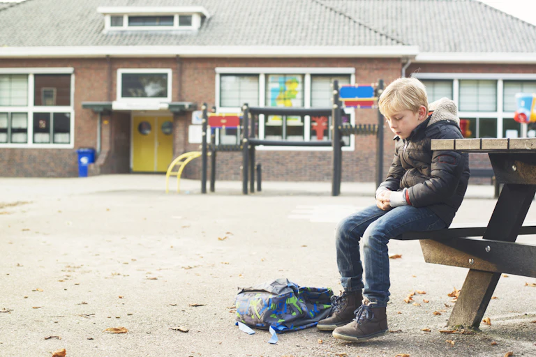 jeune garçon triste dans une cour d'école