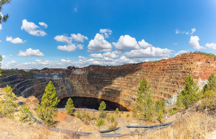 Enorme mine ouverte à flanc de colline et plongeant profondément dans le sol