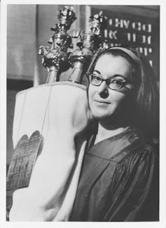 A female student holding a Torah scroll.