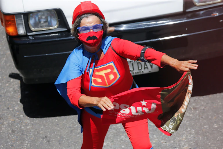 A child wearing a blue cape and red costume.