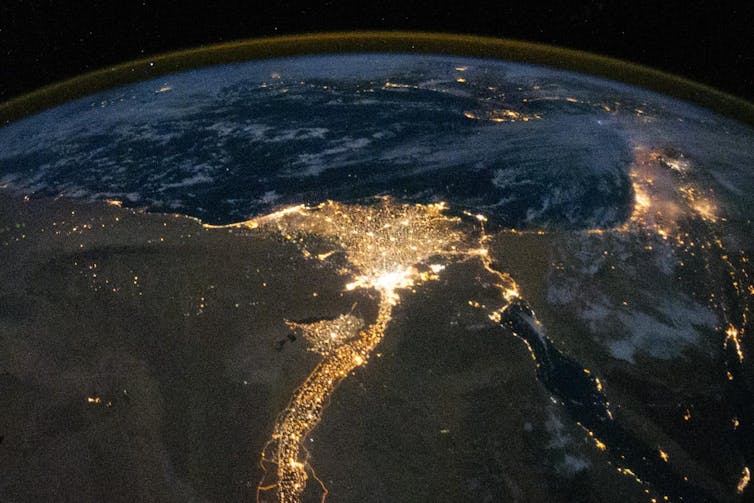 Photo showing the Nile and its delta brightly lit at night.