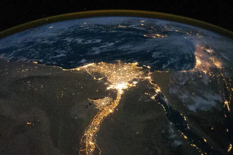 Photo showing the Nile and its delta brightly lit at night.