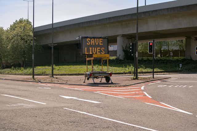 a display sign underneath a bypass reading SAVE LIVES