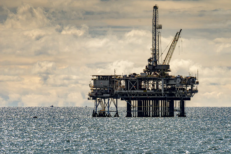 An oil rig offshore in choppy water.
