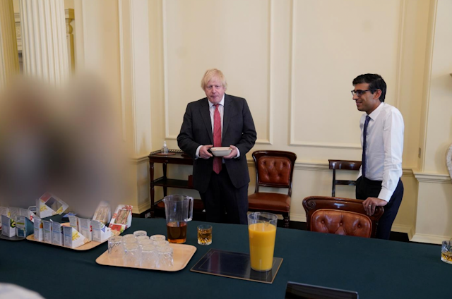 Boris Johnson and Rishi Sunak standing in front of a table of sandwiches and drinks in a photo taken from the Sue Gray report. 