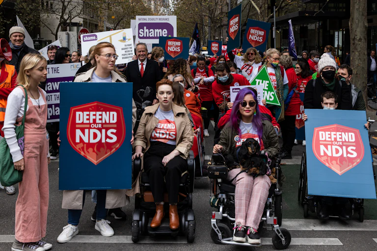 Large crowd protest in street to protect NDIS
