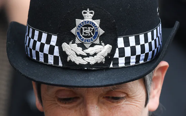 Close up of Cressida Dick's eyes, looking downward, and commissoner's hat
