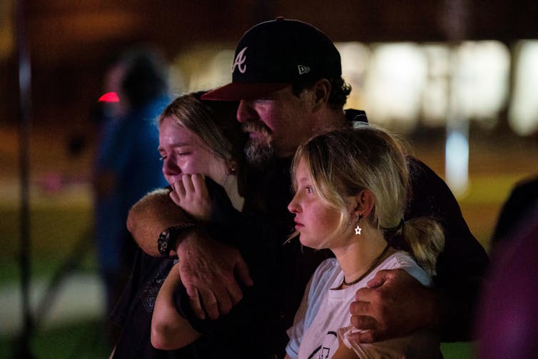 Two children and an adult crying.