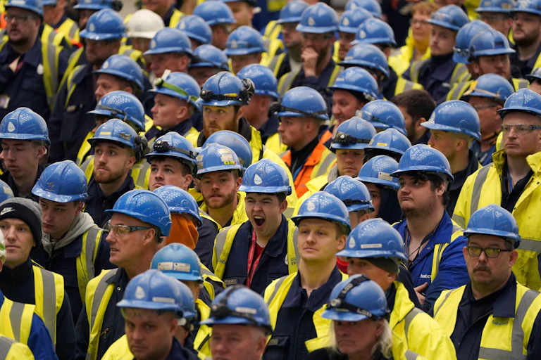 Lots of men in hard hats and hi-vis vests