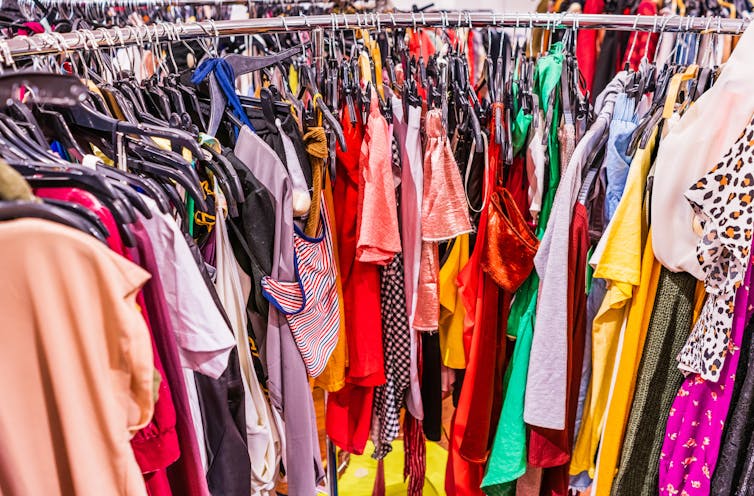 Cluttered rack of colourful fast fashion clothing
