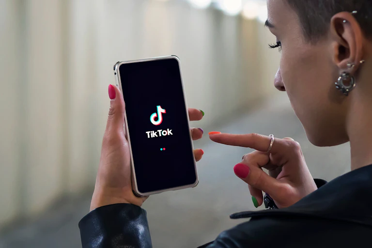 A woman looks at her phone opening the TikTok app