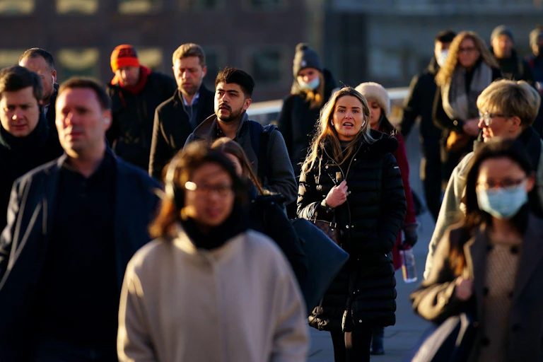 Workers walking in a crowd towards offices