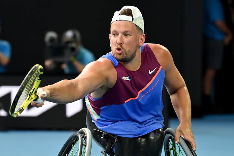 man hits tennis ball in wheelchair